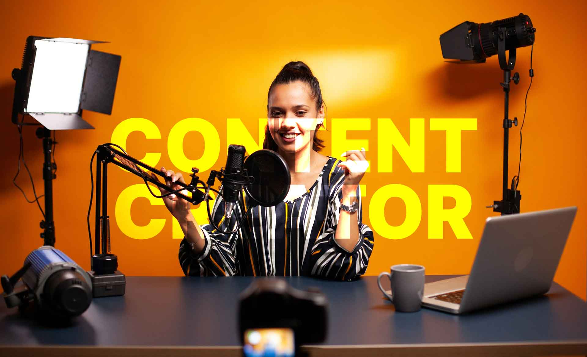 woman talking in front of camera to create engaging video content in her studio with orange background