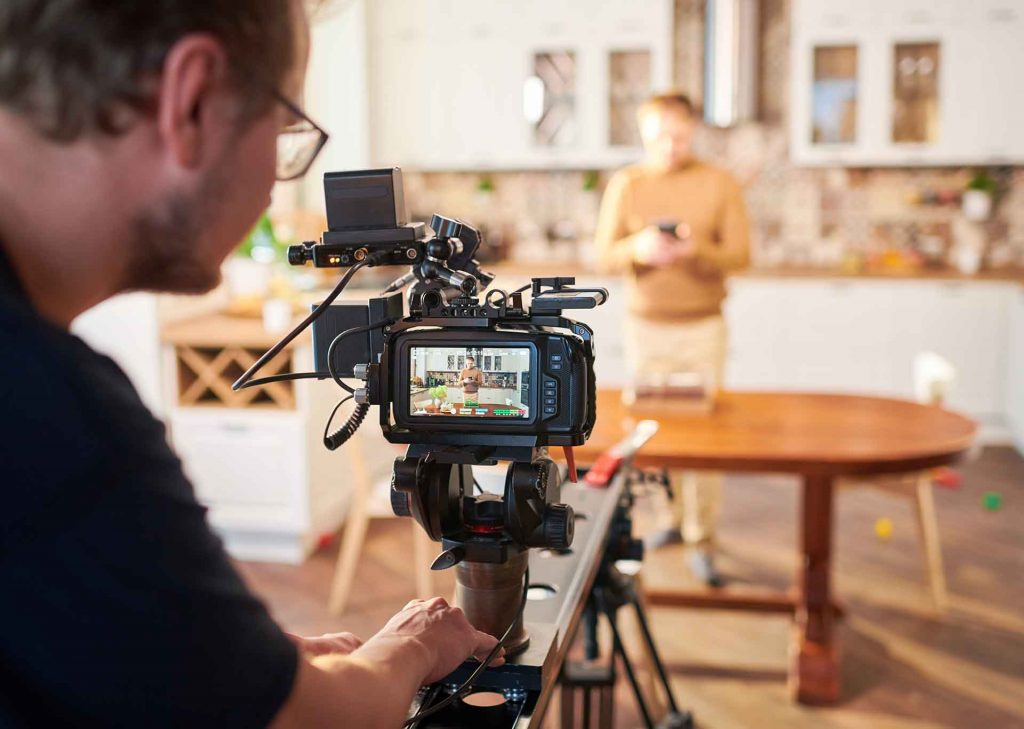 cameraman taking a video of a content creator in his studio set