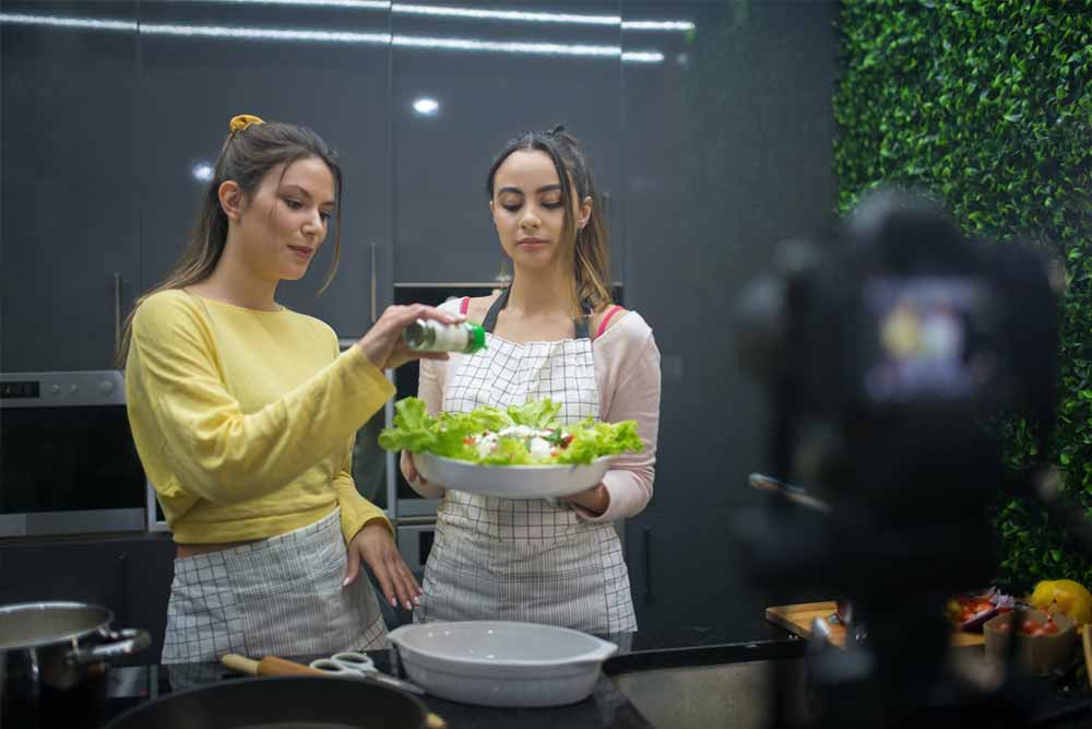 content creator makanan sedang menambahkan bumbu ke masakannya