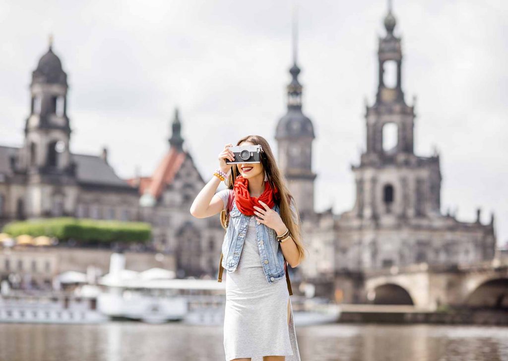 seorang wanita yang sedang traveling dan mengambil gambar dengan kamera